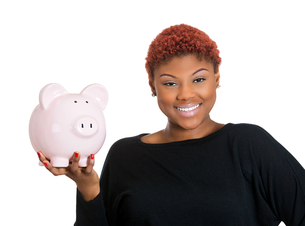 Closeup portrait of young woman holding her piggy bank friend in hand, isolate on white background. Positive emotion facial expression feelings. Smart wise saving paid financial decisions. Nest egg