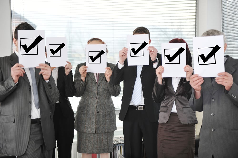 Successful team holding check mark vote sign