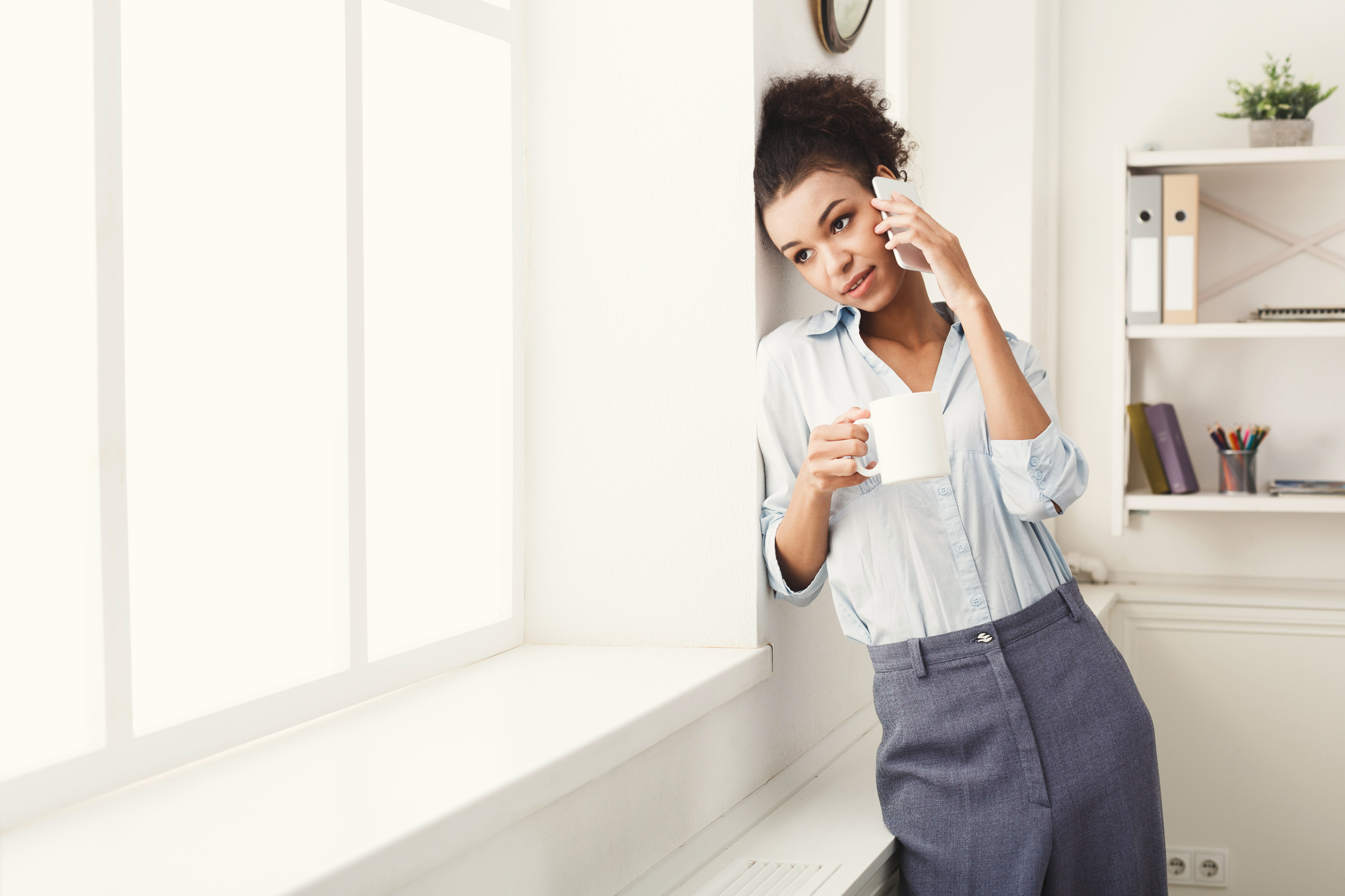 business-woman-has-phone-talk-near-office-window-P6DMPS3