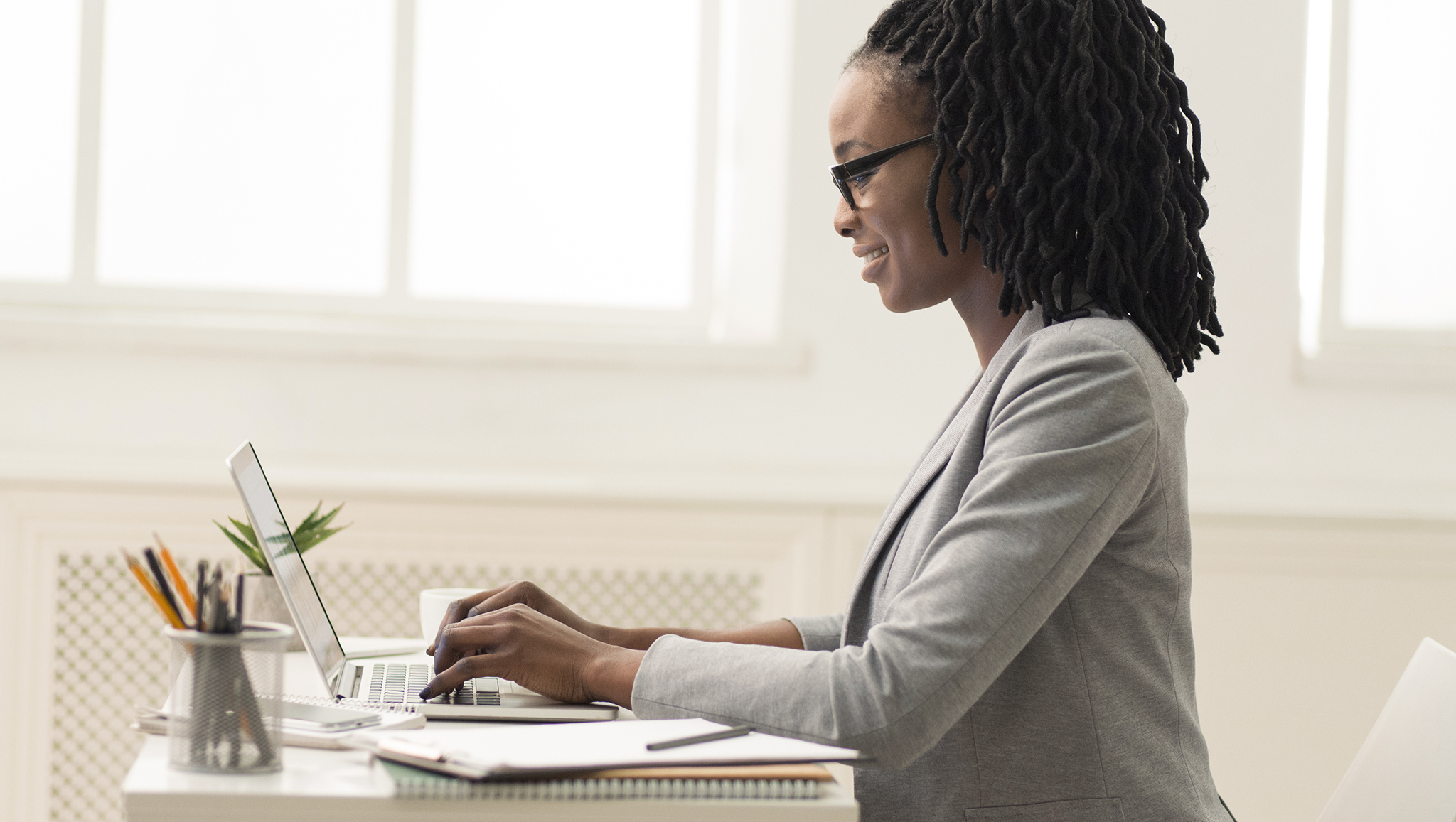 african-american-lady-using-laptop-in-office-side-AVD3H7F