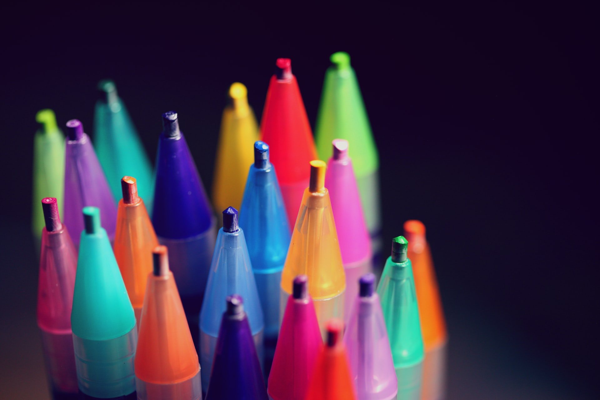 cluster of multi-colored pen tips against a black background