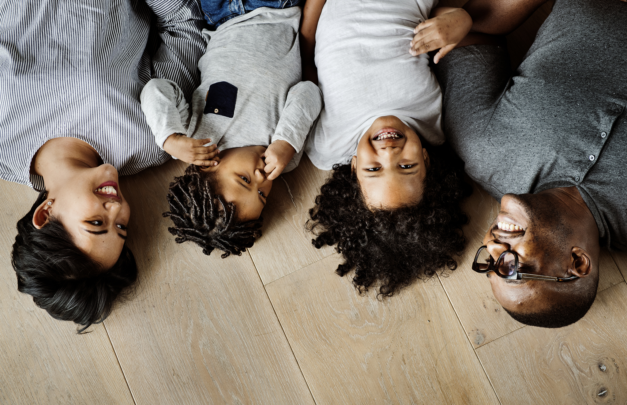 black-family-lying-on-wooden-floor-design-space-PB9ZRPG