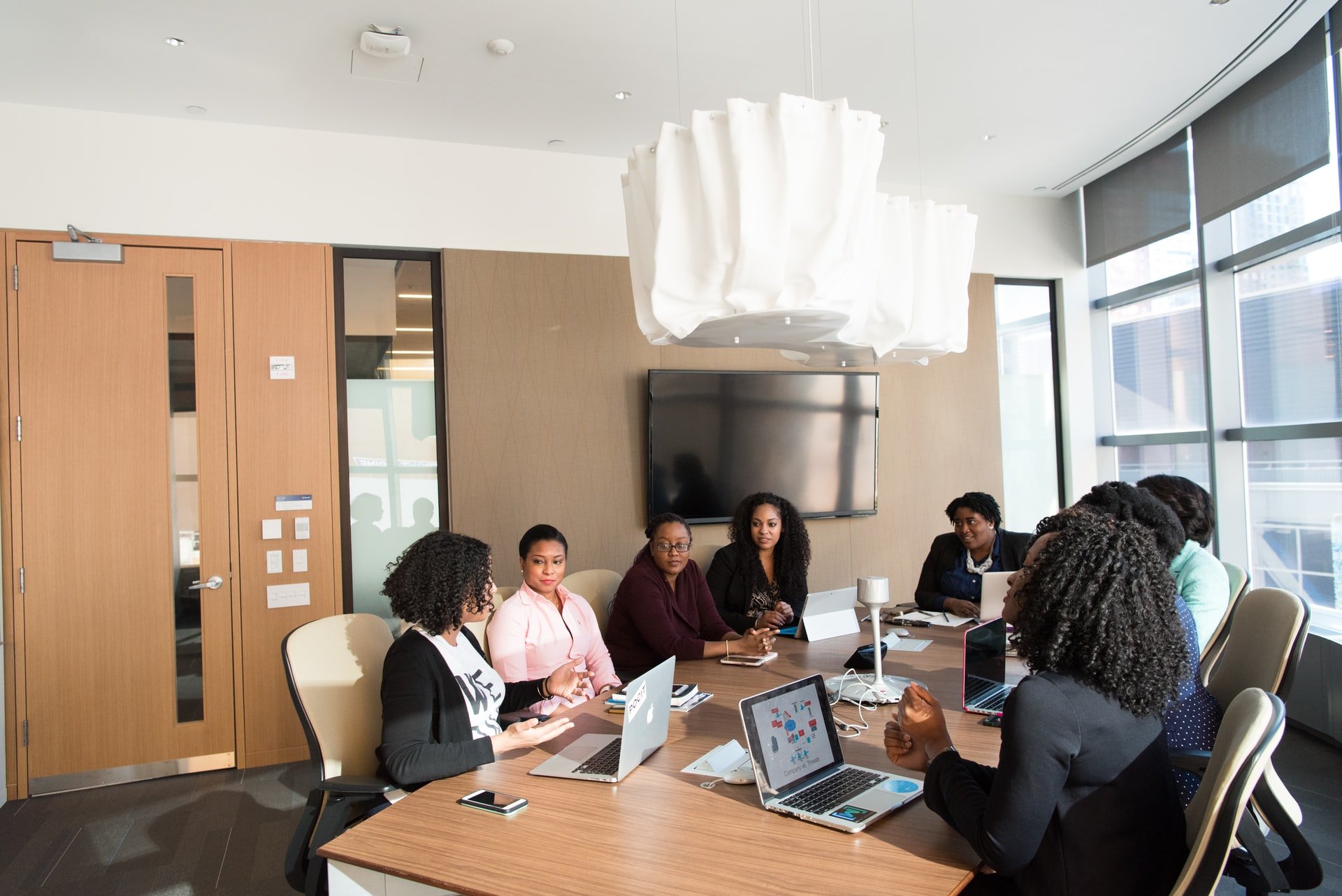 work meeting around conference table with laptops