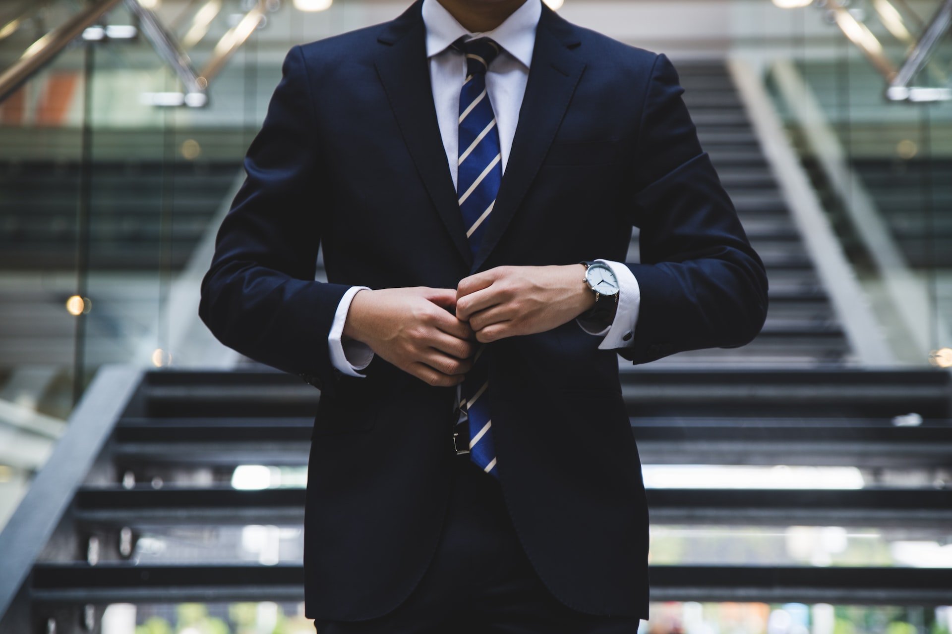 business person wearing suit from neck, down, wearing a watch and necktie 