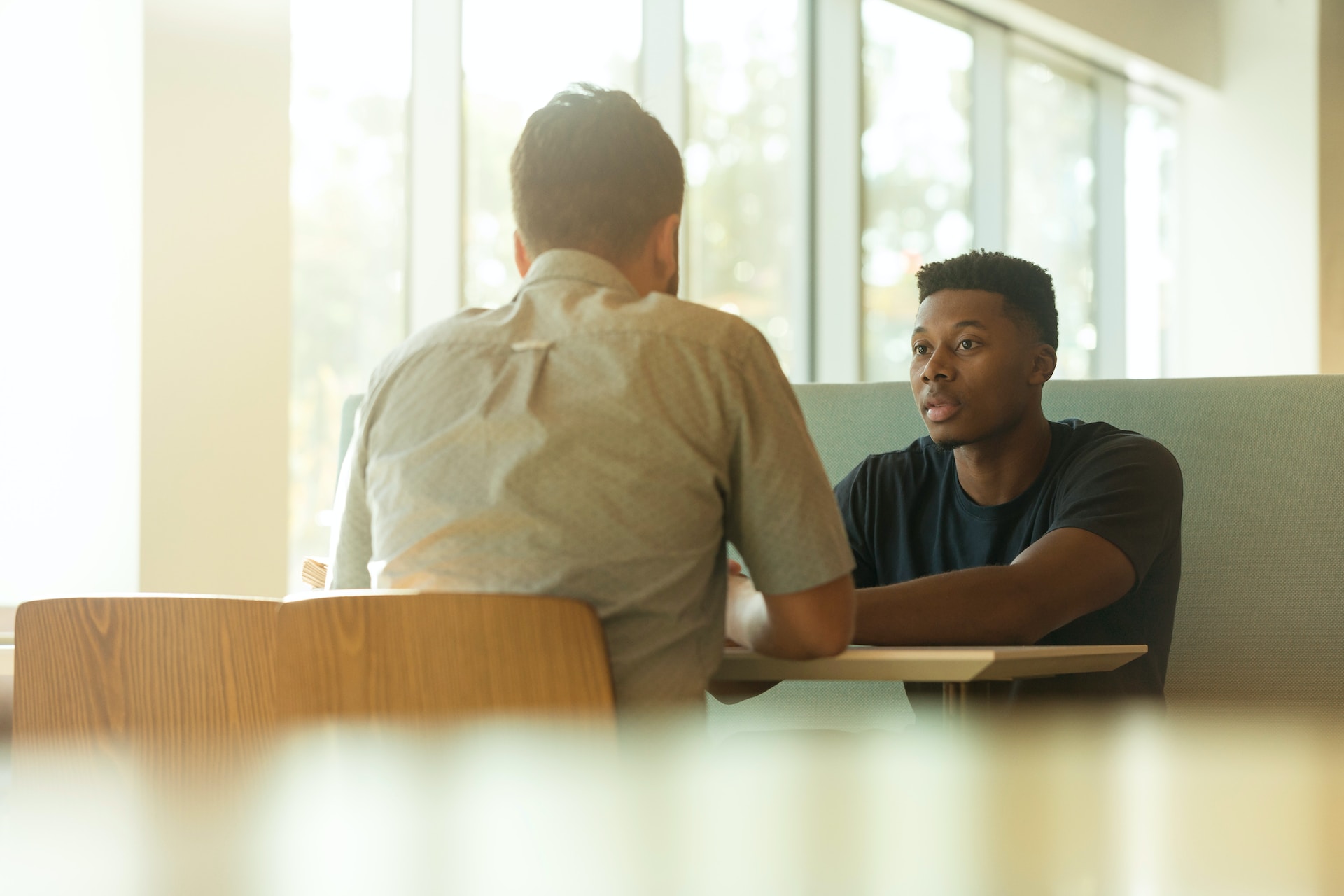 two people sitting across from each other at a table