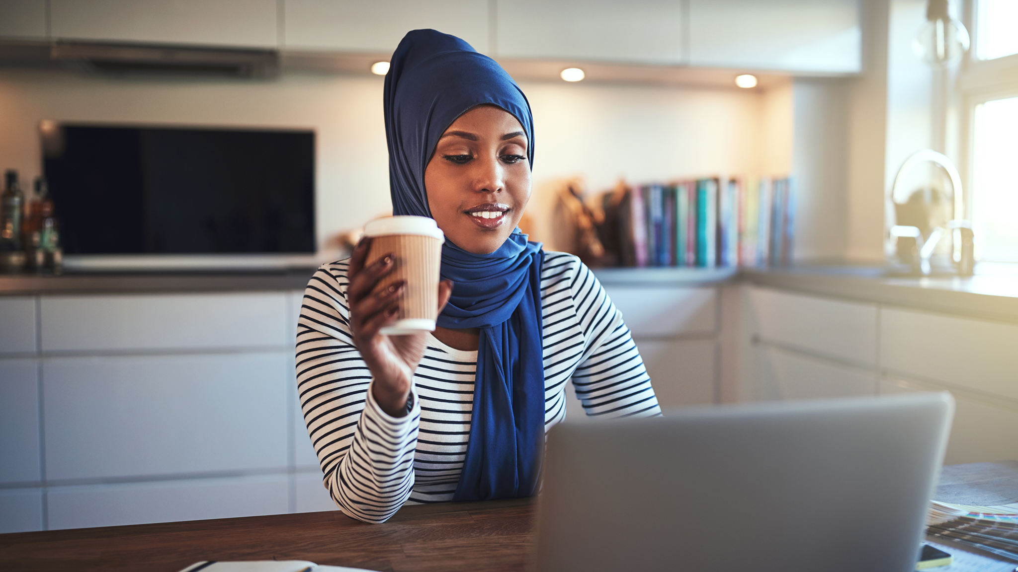 young-arabic-woman-drinking-coffee-and-working-JCBW54R